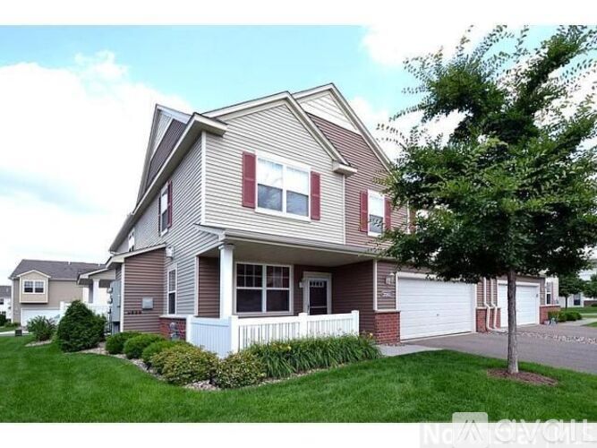 A house with a grey and red exterior and a white fence.
