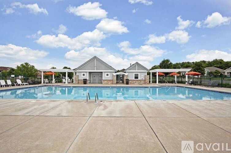 A large swimming pool with a house in the background.