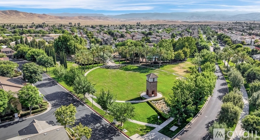 A bird's eye view of a residential area with a roundabout and houses.
