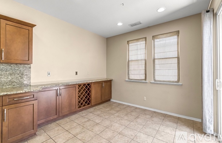 A kitchen with brown cabinets and a granite countertop.