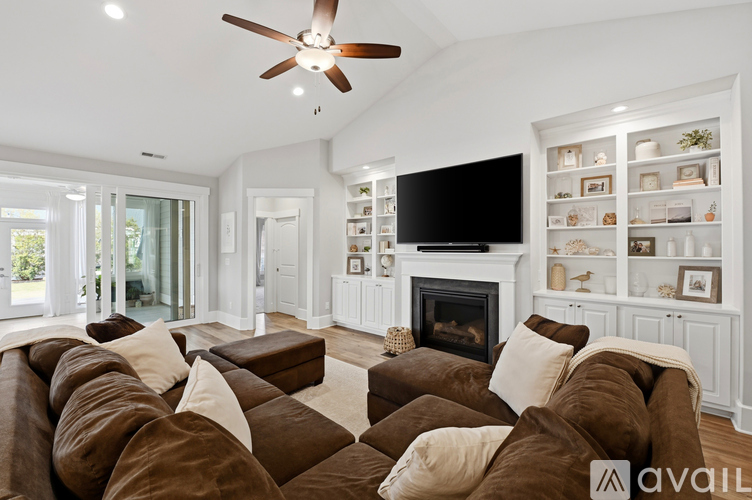 A living room with a brown couch and a fireplace.