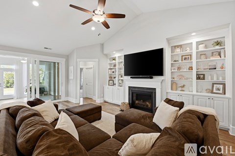 A living room with a brown couch and a fireplace.