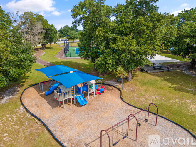 A playground with a blue canopy and a slide.