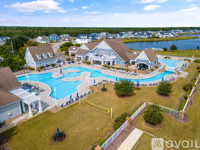 A large swimming pool surrounded by a grassy area and a few trees.
