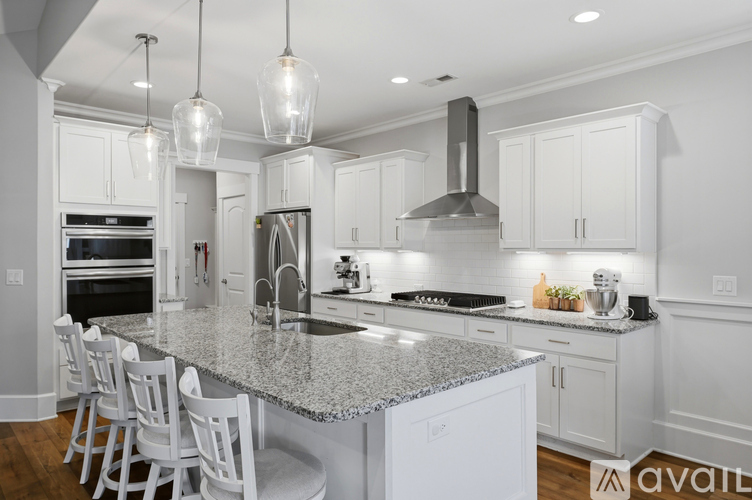 A kitchen with granite countertops and white cabinets.