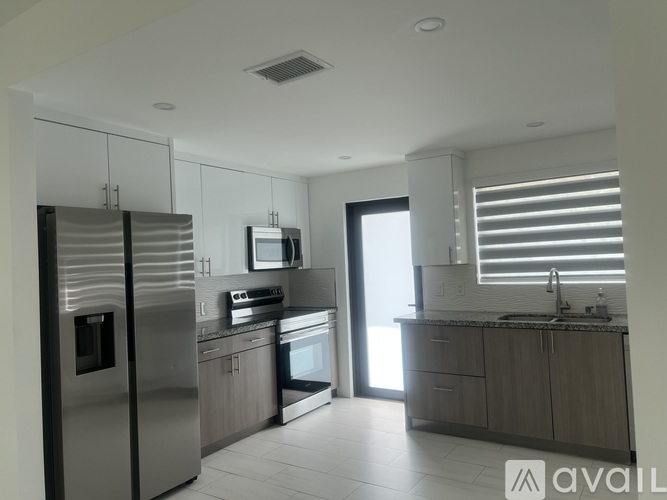 A modern kitchen with stainless steel appliances and wooden cabinets.