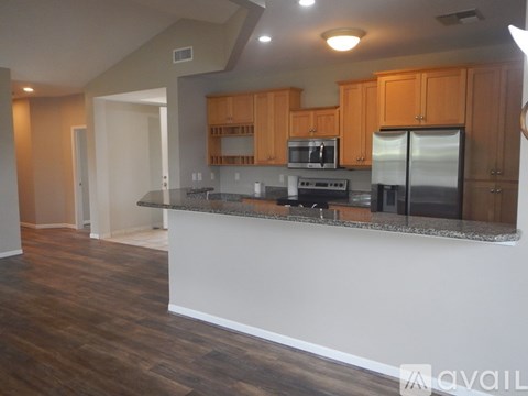 A kitchen with wooden cabinets and a granite countertop.