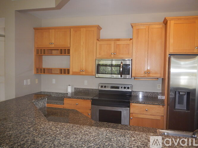 A kitchen with wooden cabinets and granite countertops.