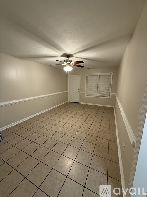 A room with a ceiling fan and tiled floor.