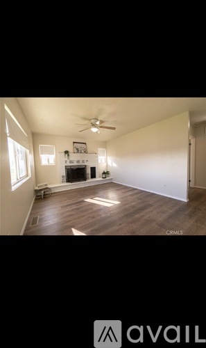 A room with a ceiling fan and wooden flooring.