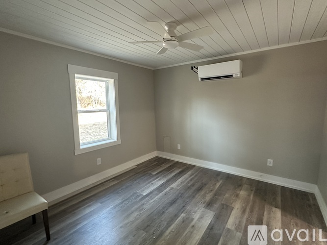 A room with a window and a ceiling fan.