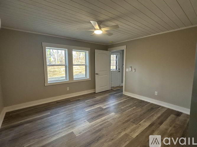 A room with a wooden floor and a ceiling fan.