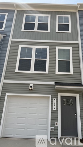 A grey house with a white garage door and a black door.