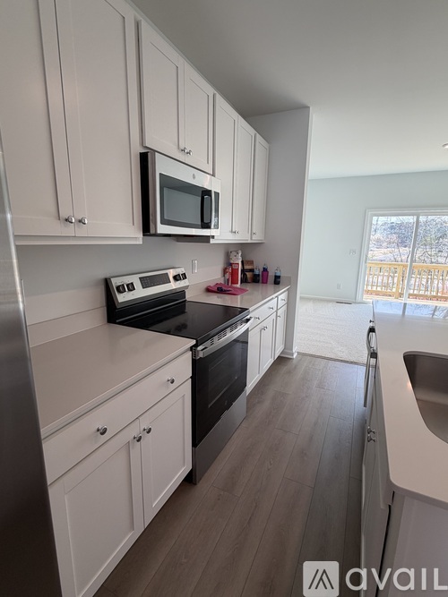 A kitchen with white cabinets and a black stove top oven.