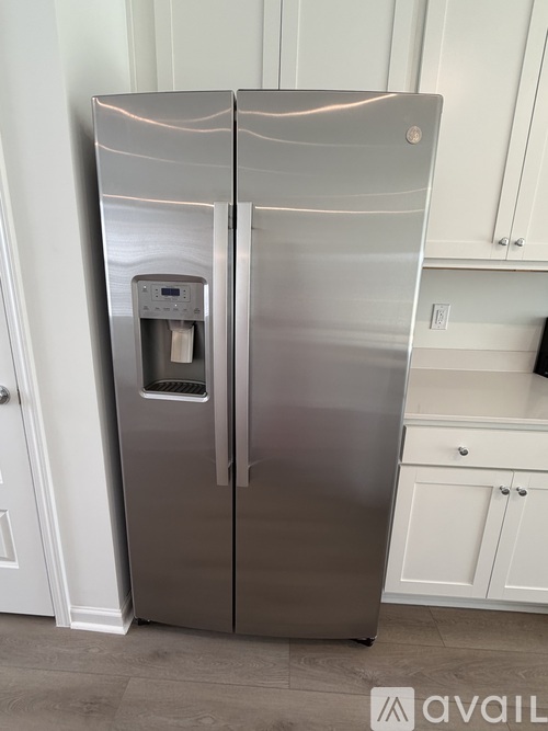 A stainless steel refrigerator with a water dispenser on the door.