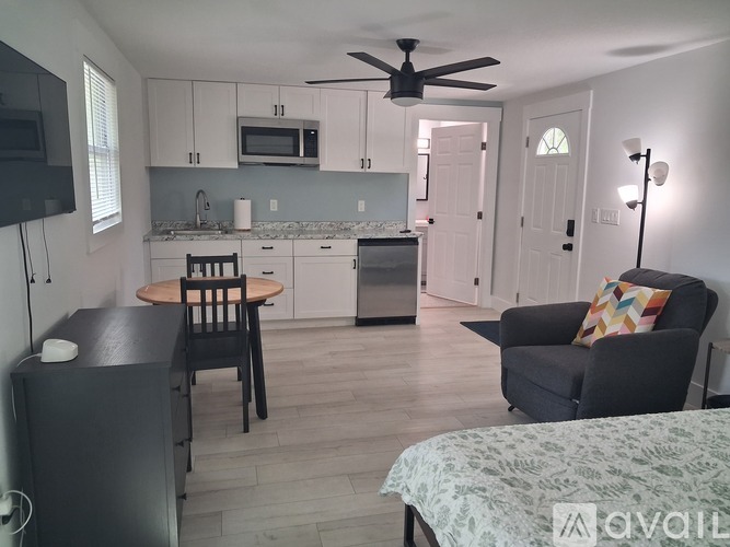 A kitchen with a table and chairs and a ceiling fan.