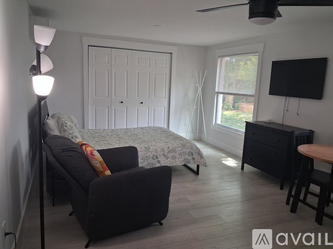 A living room with a grey couch and a white door.