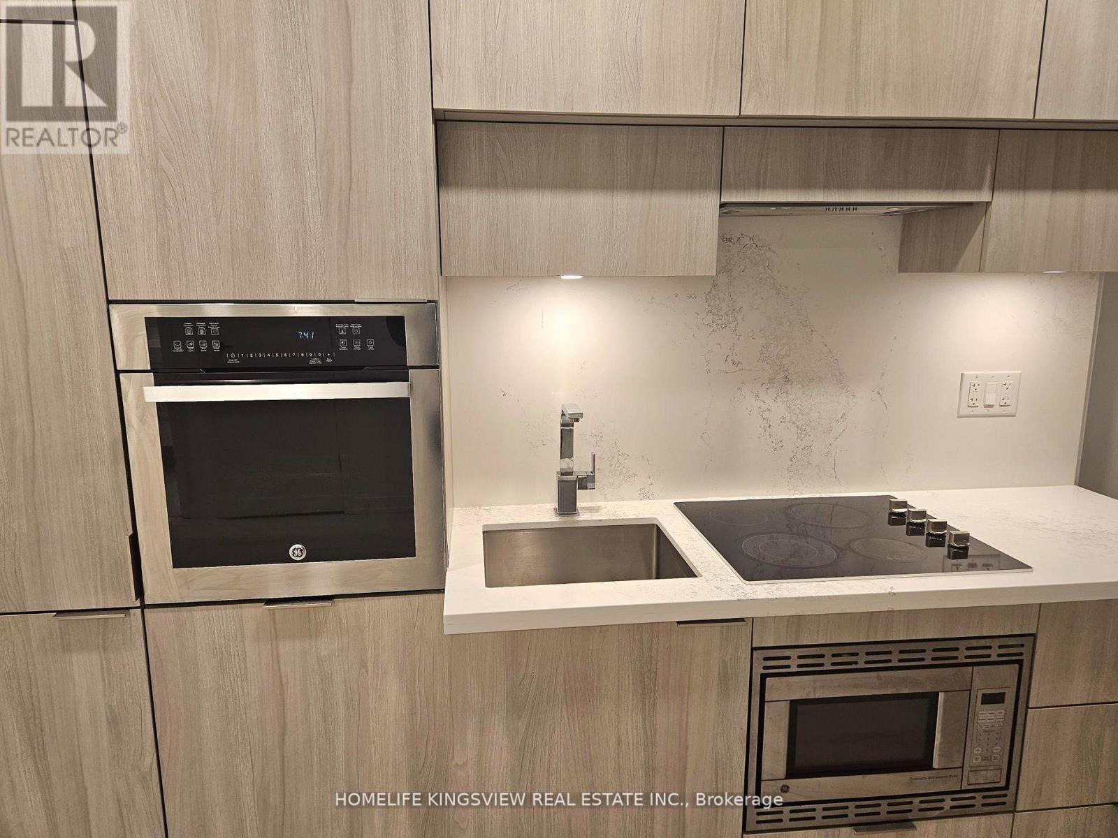 A modern kitchen with a stainless steel oven and microwave.