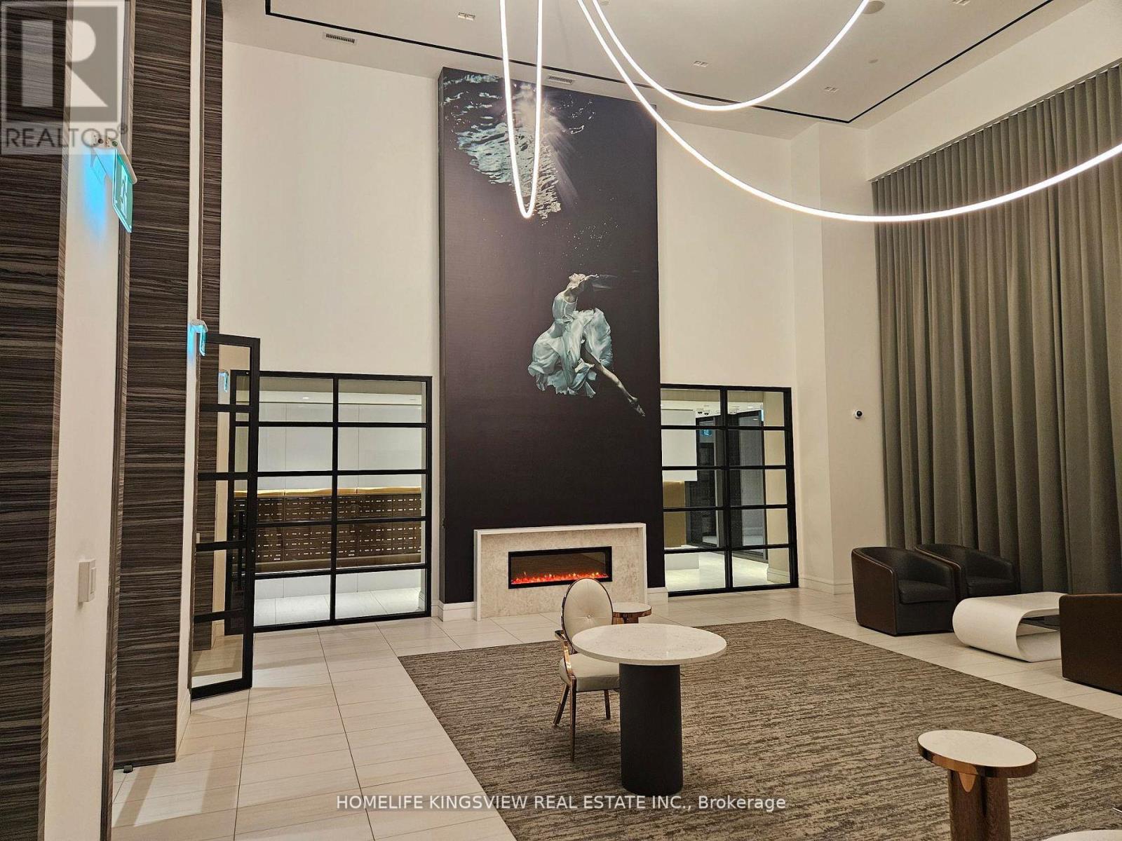 A modern living room with a fireplace and a large painting on the wall.