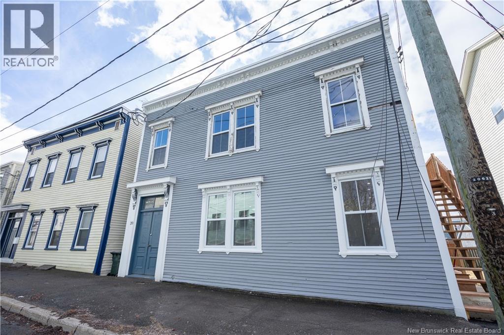 A grey house with a blue door is for sale.