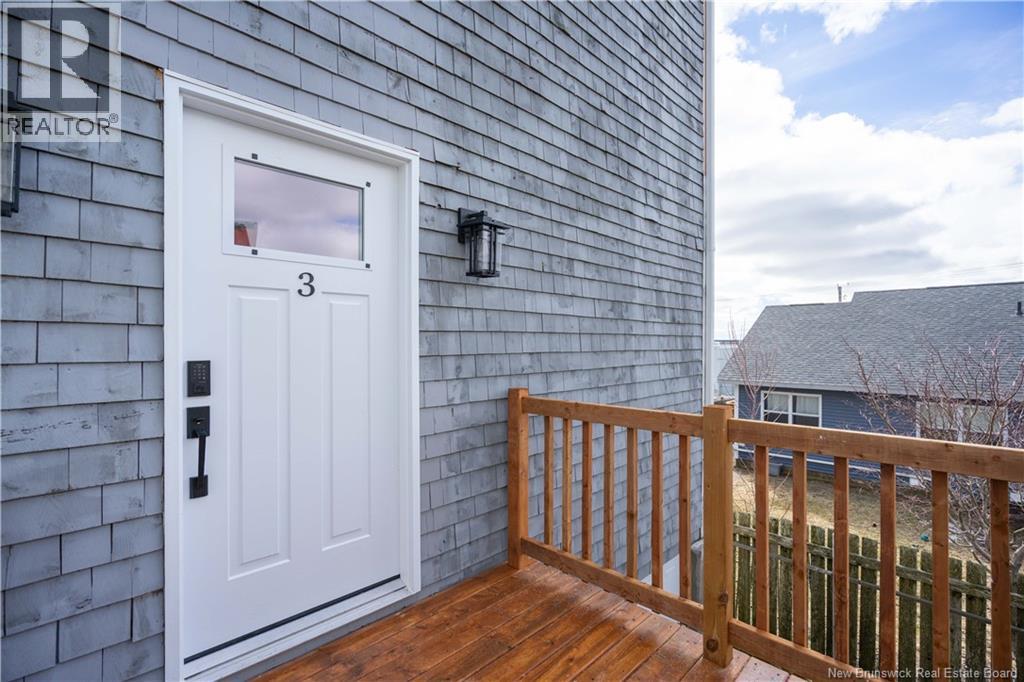 A white door with the number 3 on it is on a grey building.