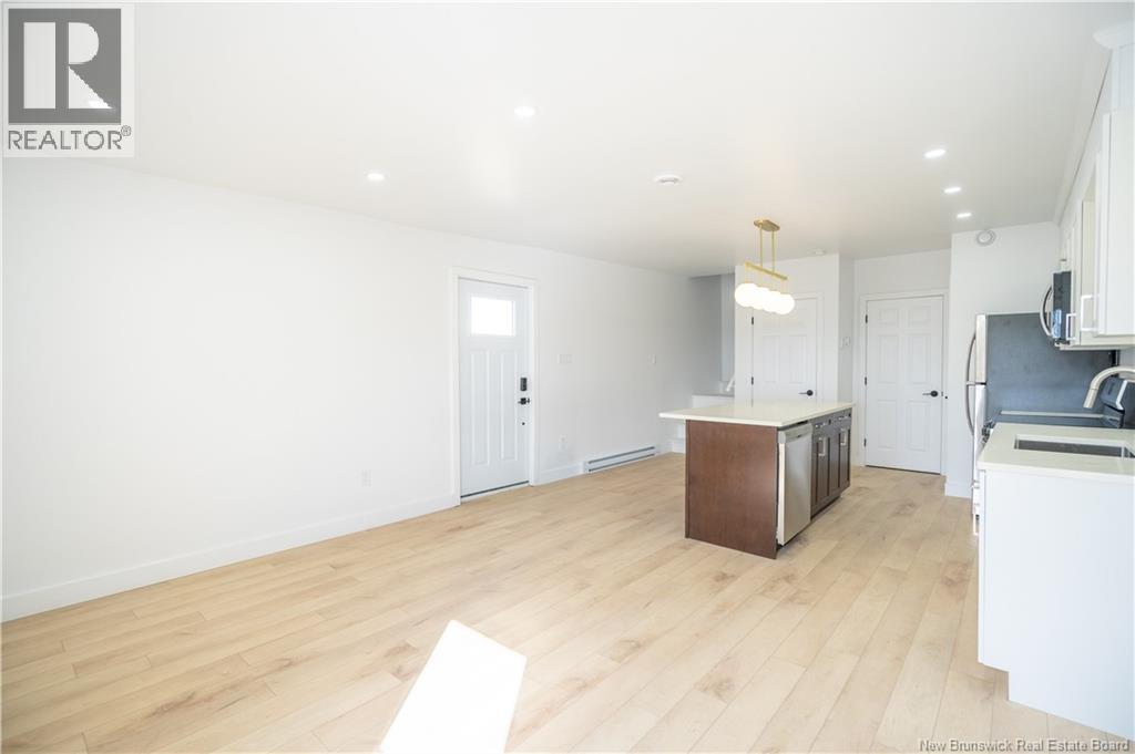 A spacious kitchen with white cabinets and a wooden island.