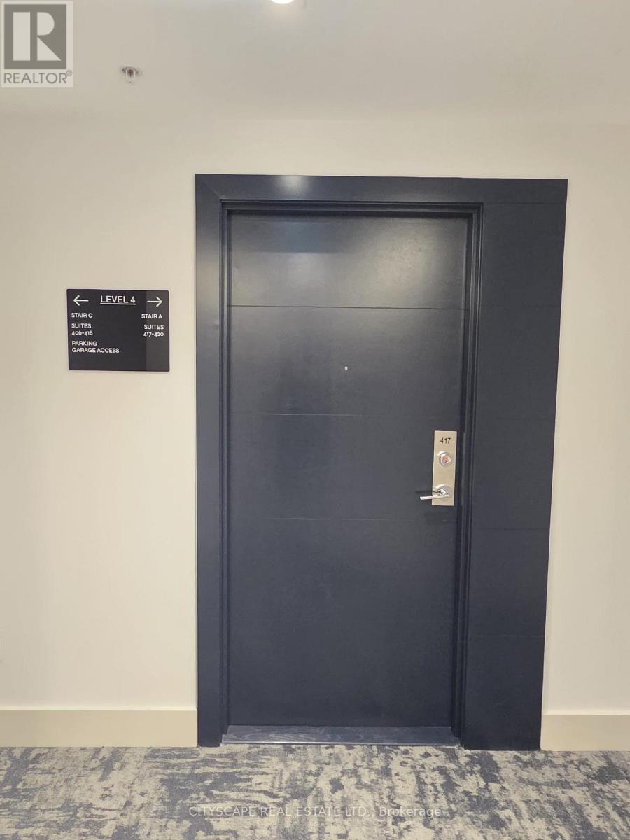 A black door with a sign on the wall above it.