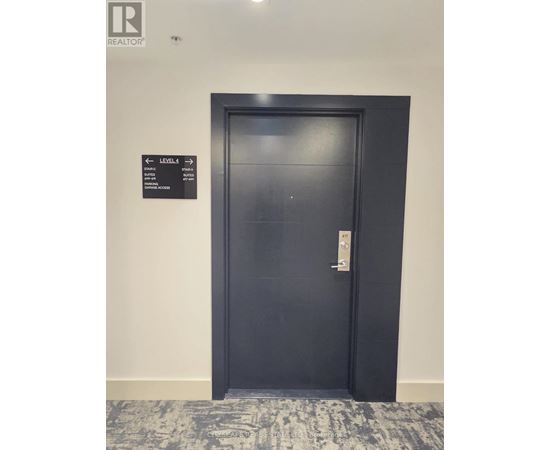 A black door with a sign on the wall above it.