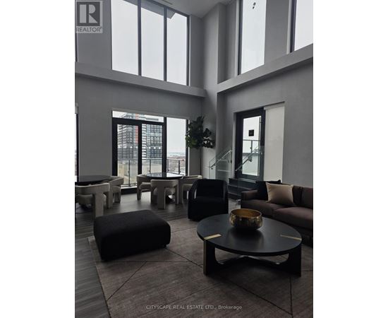 A living room with a black coffee table and a large window.