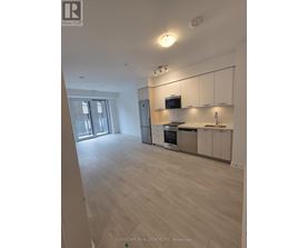 A spacious kitchen with white cabinets and stainless steel appliances.