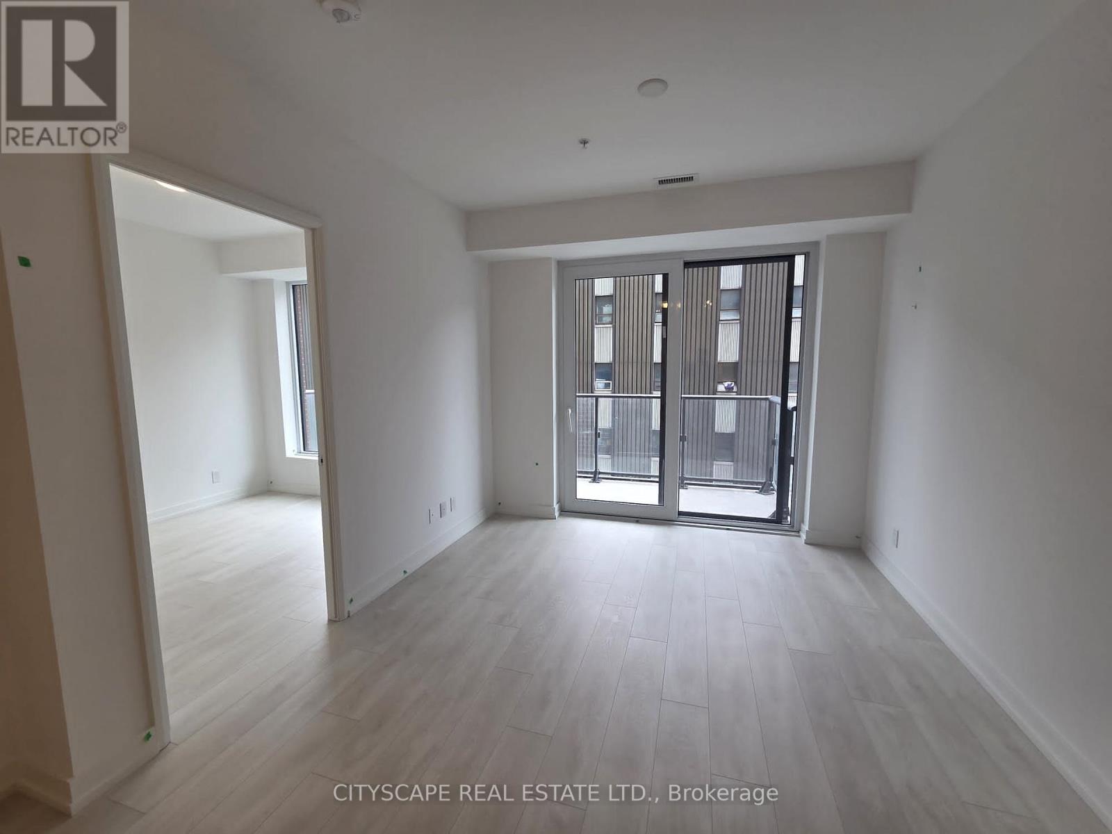 A spacious room with a view of a balcony through a glass door.