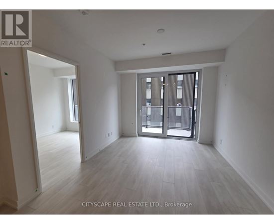 A spacious room with a view of a balcony through a glass door.