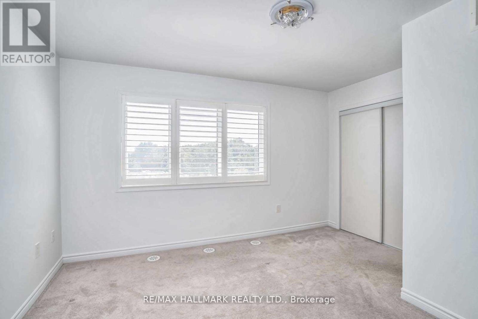 A white bedroom with a window and a sliding door.