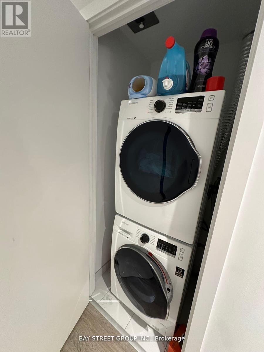 A washing machine is in a small space with a few bottles on top.