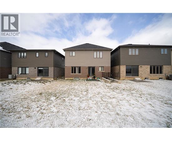 A realtor photo of a row of houses in a snowy field.