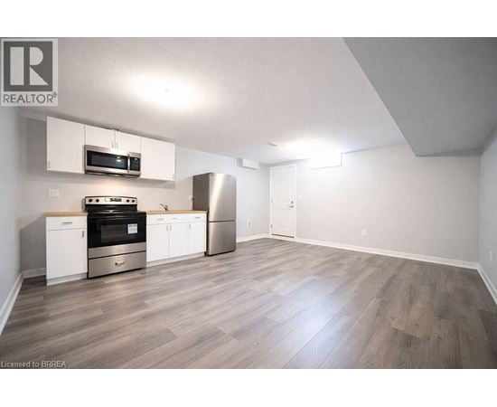 A kitchen with a stove top oven, microwave, and refrigerator.