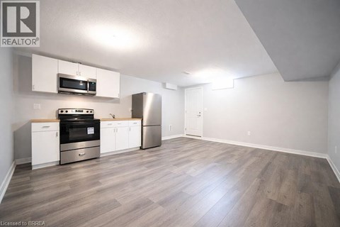 A kitchen with a stove top oven, microwave, and refrigerator.