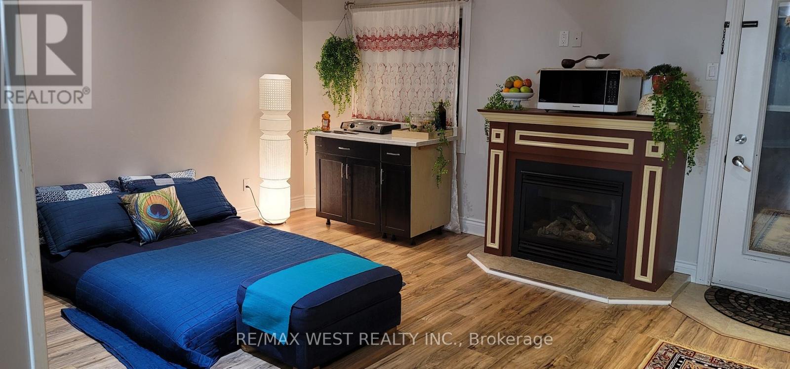 A bedroom with a blue bedspread and a fireplace.