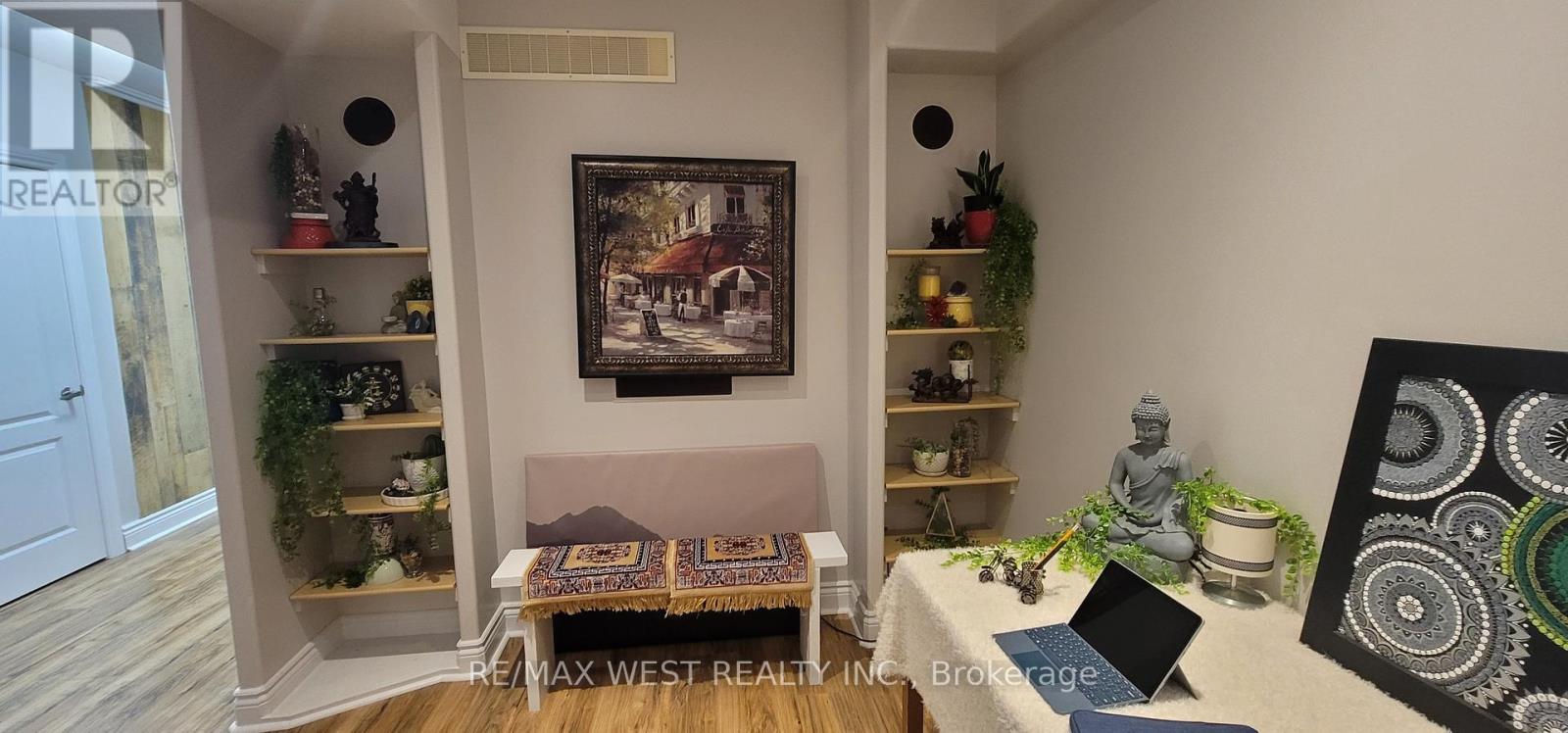 A room with a couch, a table, and a painting on the wall.