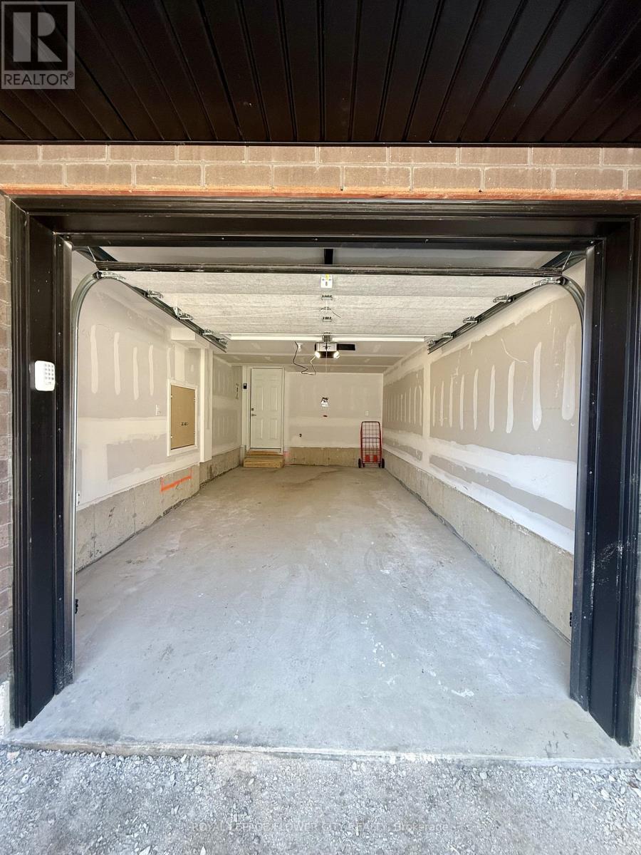 A large, empty garage with a brick wall and a concrete floor.
