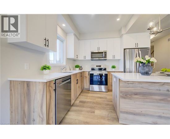 A modern kitchen with wooden cabinets and stainless steel appliances.