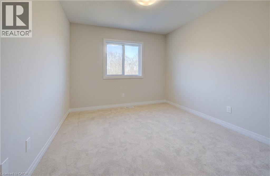 A white bedroom with a window and carpeted floor.