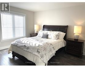 A bedroom with a large bed and two lamps.