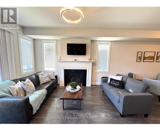 A living room with a fireplace and a television on the wall.