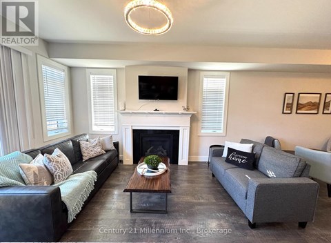 A living room with a fireplace and a television on the wall.