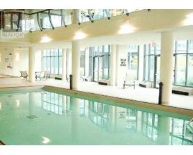 A large indoor swimming pool with a glass bottom.