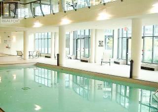 A large indoor swimming pool with a glass bottom.