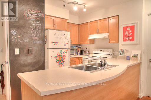A kitchen with a chalkboard wall and a white fridge.