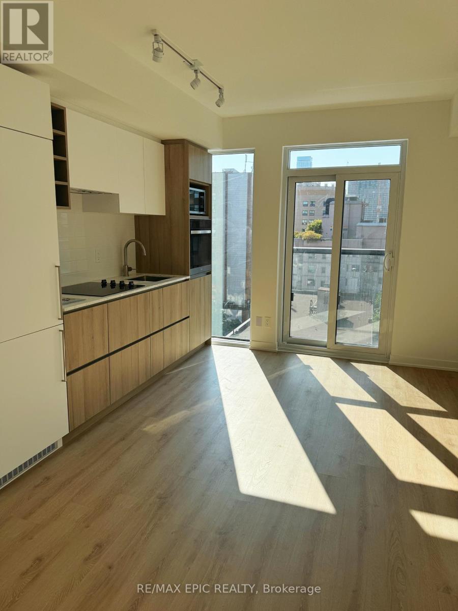 A well-lit kitchen with wooden floors and white cabinets.