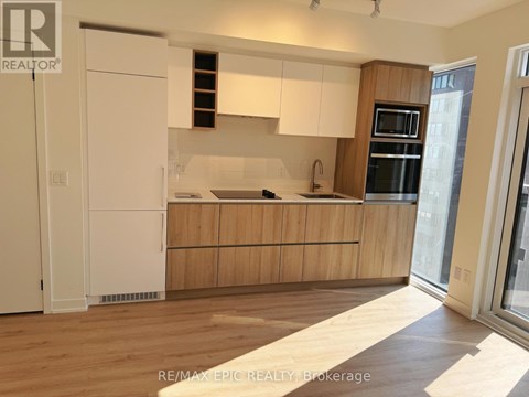 A kitchen with wooden cabinets and a white fridge.